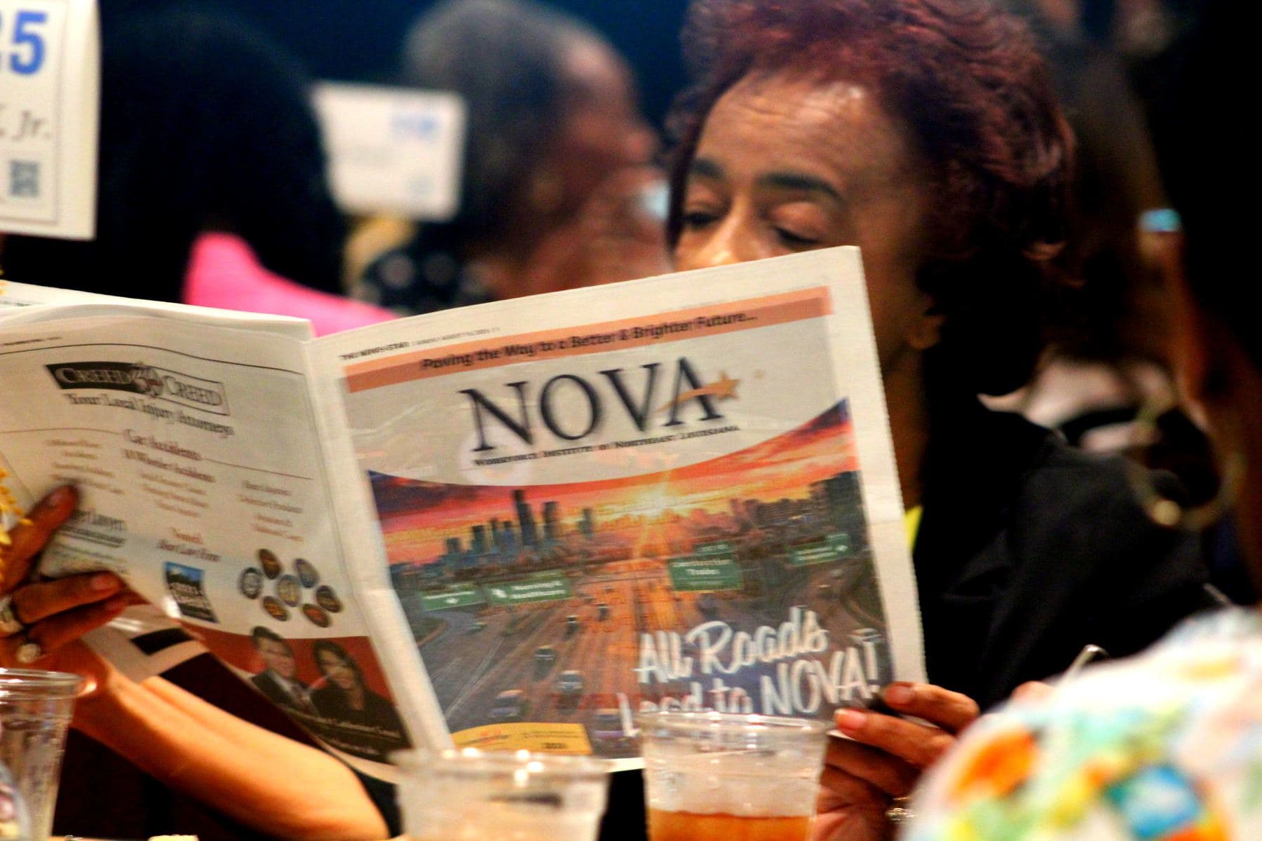 A luncheon guest reading NOVA's event program