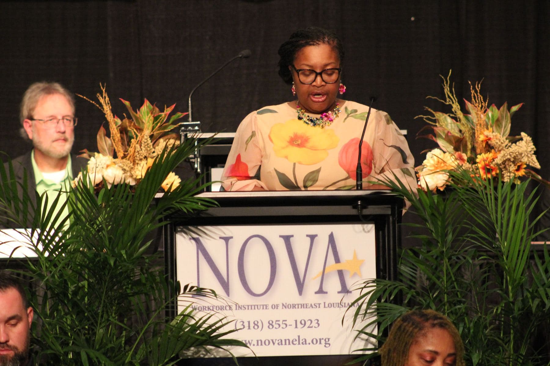 A community leader speaking from the NOVA podium during the luncheon