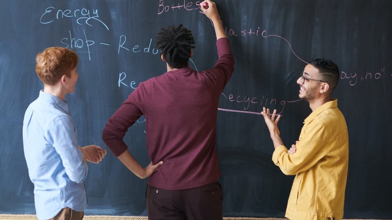 A group developing ideas together on a chalkboard