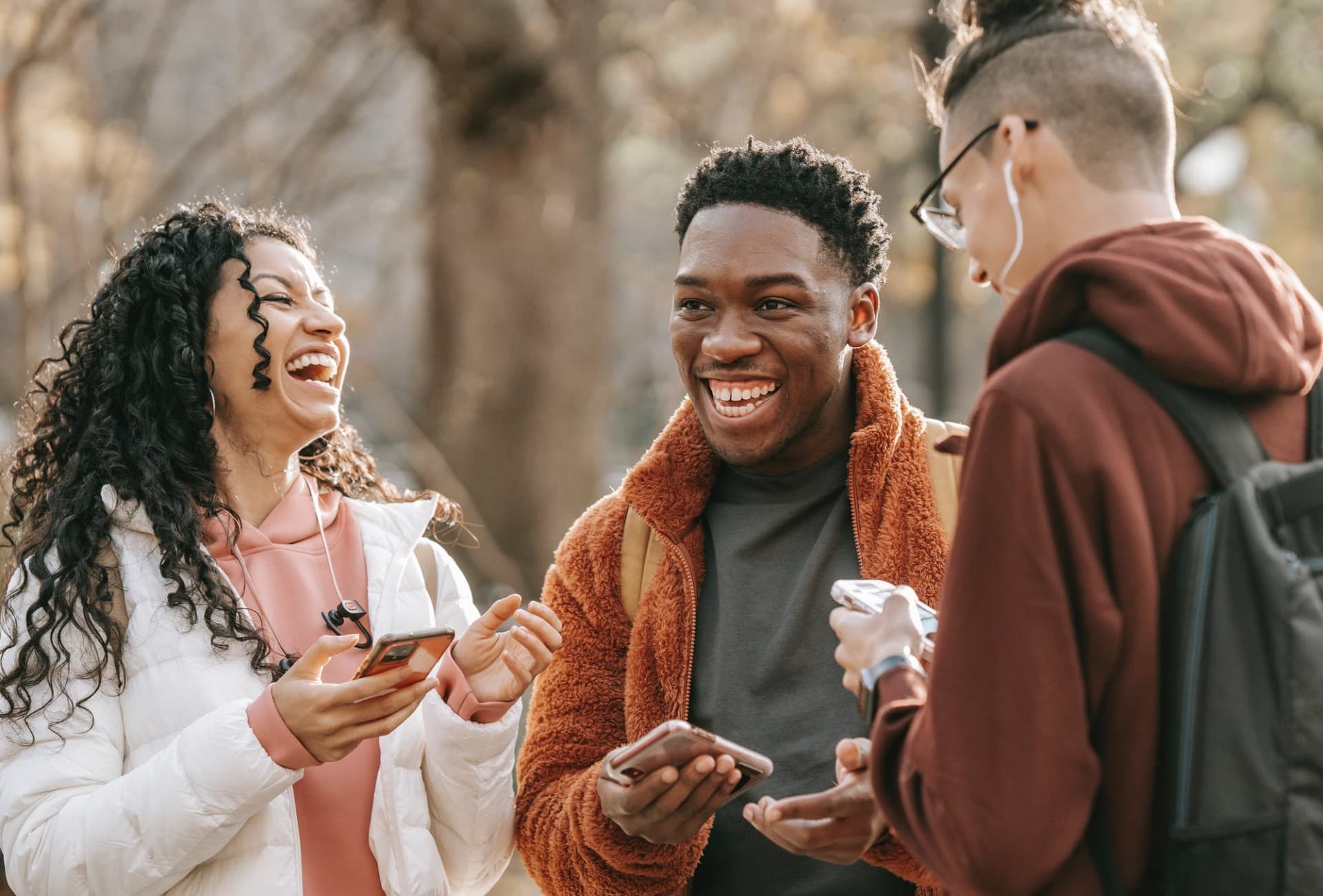 Three friends sharing a conversation outdoors